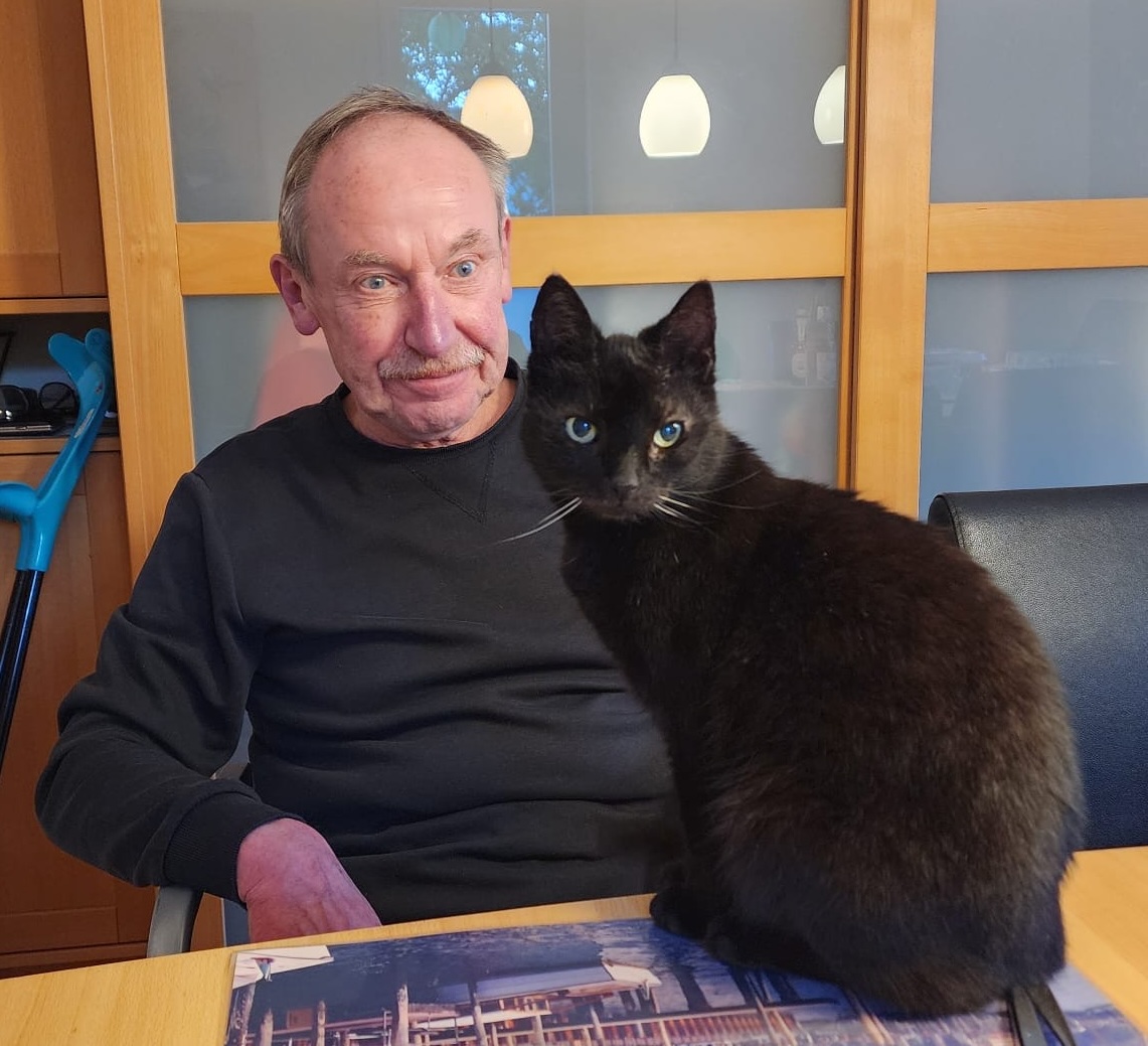 Albert Heinecke mit seiner Katze am Küchentisch